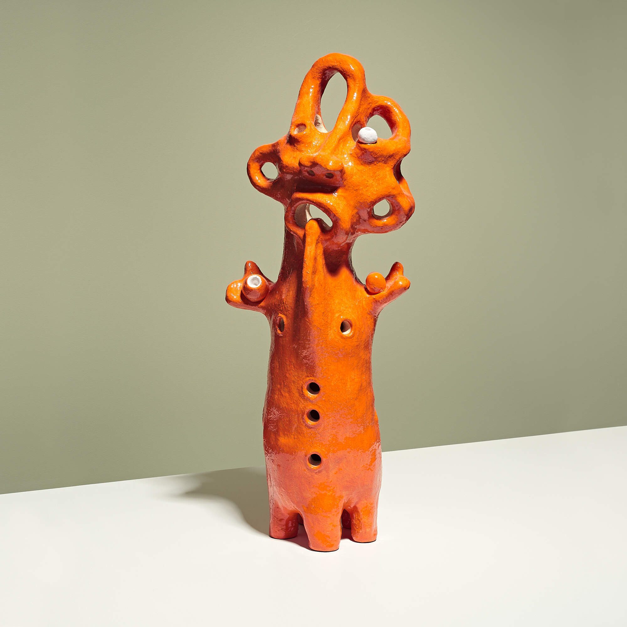 Contemporary, hand-built, textured clay ceramic sculpture of a mythical creature with glossy, vibrant orange glaze. Australia. Vietnam