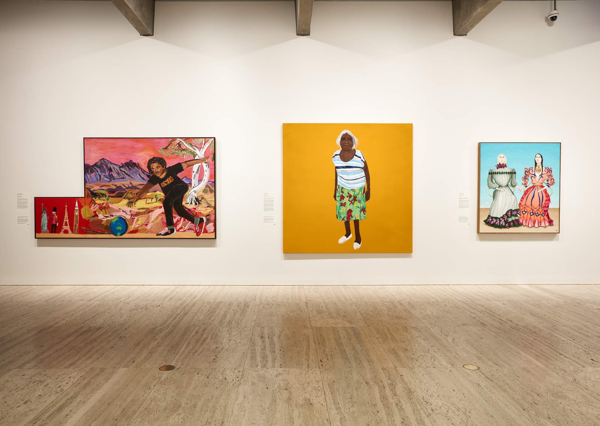 Photo of three large paintings hanging on a white gallery wall